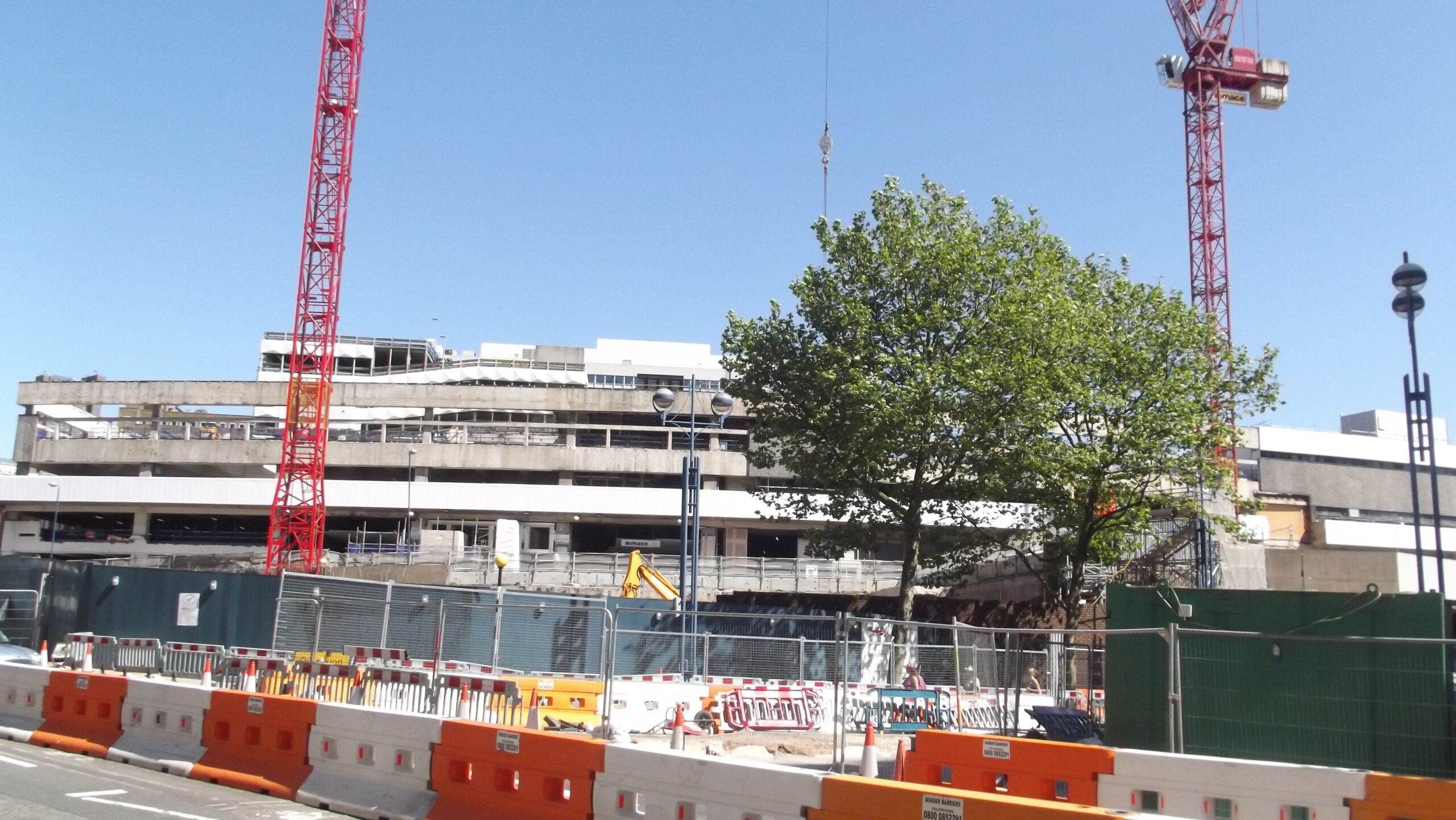 Workers and machinery removing the concrete façade of Birmingham New Street Station